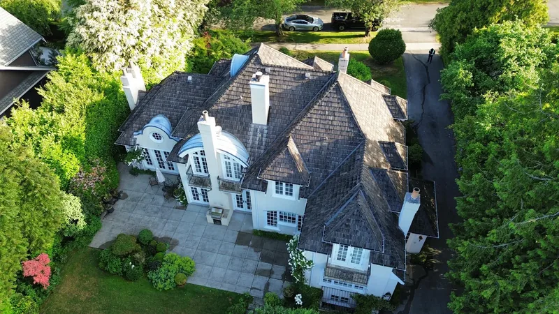 Overhead view of the original cedar shake roof, dormers and multiple chimneys before replacement