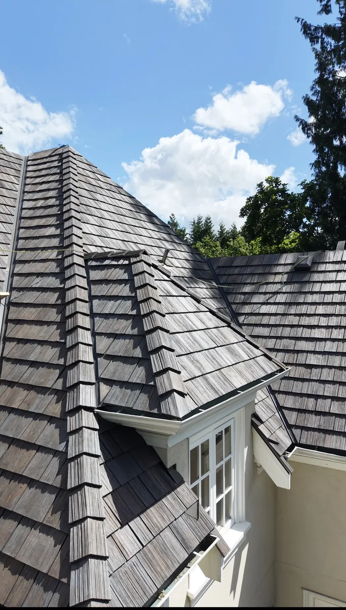 Brava composite cedar shake roof detail — ridge and hip lines across a steep-pitch dormer